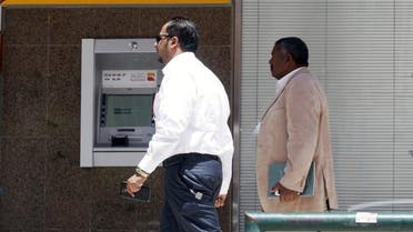 Men walk pass an automated teller machine (ATM) outside Bank Al Bilad in Riyadh, Saudi Arabia, April 25, 2016. (Reuters)