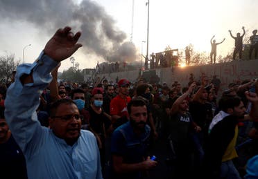 Iraqi protesters shout slogans during an anti-government protest near the burnt building of the government office in Basra. (Reuters)