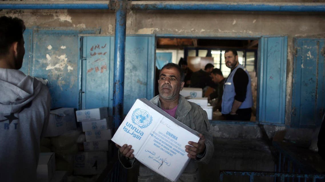 In this Jan. 14, 2018 photo, Palestinians receive food aid at a U.N. Relief and Works Agency warehouse in the Shati refugee camp, Gaza City. (AP)