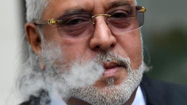 Vijay Mallya smokes outside Westminster Magistrates Court in London on September 12, 2018. (Reuters)