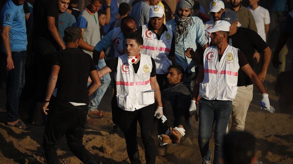 Paramedics carry a wounded Palestinian protester during a demonstration along the Israeli fence east of Gaza City on September 14, 2018. (AFP)