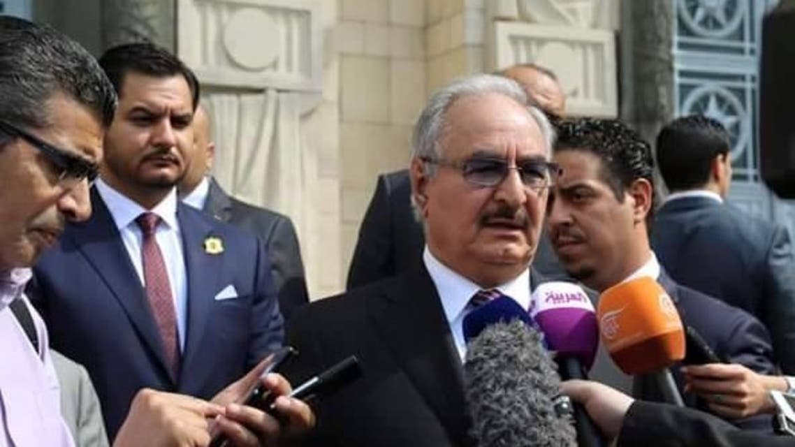 صدام حفتر واقفاً وراء قائد الجيش الليبي خليفة حفتر