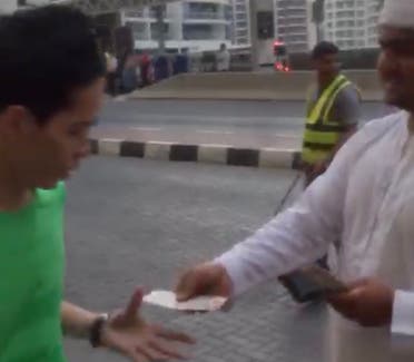 Another video grab of a man in traditional Arab dress seen “distributing cash among strangers” in Dubai.