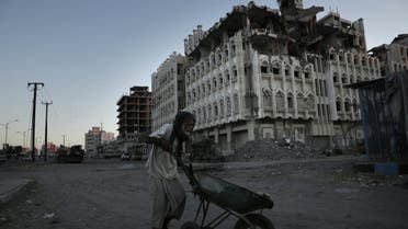 A man walks past a damaged building in Aden, Yemen. (AP)