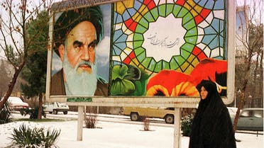 An Iranian woman passes by a billboard showing late Ayatollah Khomeini in Tehran. (File photo: AFP)