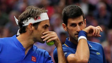 Team Europe's Roger Federer, left, whispers to Novak Djokovic during a men's doubles tennis match against Team World's Jack Sock and Kevin Anderson at the Laver Cup. (AP)