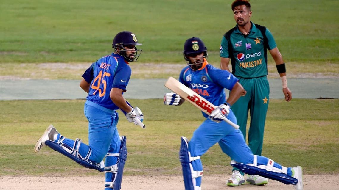 Indian captain Rohit Sharma (L) and Shikhar Dhawan (C) run between the wickets during the one day international (ODI) Asia Cup cricket match against Pakistan (AFP)