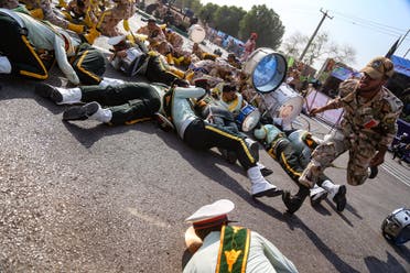 A soldier running past injured comrades lying on the ground at the scene of the attack in Ahwaz on September 22, 2018. (AFP)