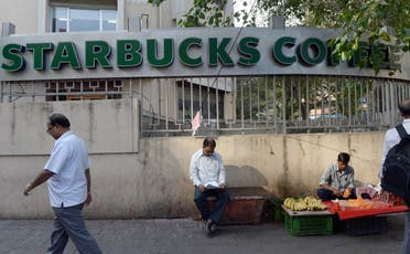 Indian pedestrians walk past a Starbucks Coffee shop in Mumbai on January 15, 2016. (AFP)
