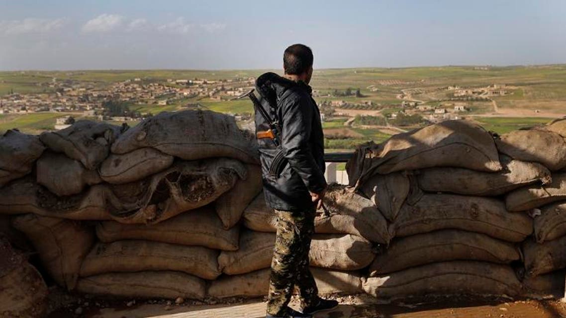 A fighter from the US-backed Syrian Manbij Military Council stands behind a sandbags barrier as he looks toward Turkish-backed fighter's position. (File photo: AP)
