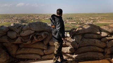 A fighter from the US-backed Syrian Manbij Military Council stands behind a sandbags barrier as he looks toward Turkish-backed fighter's position. (File photo: AP)