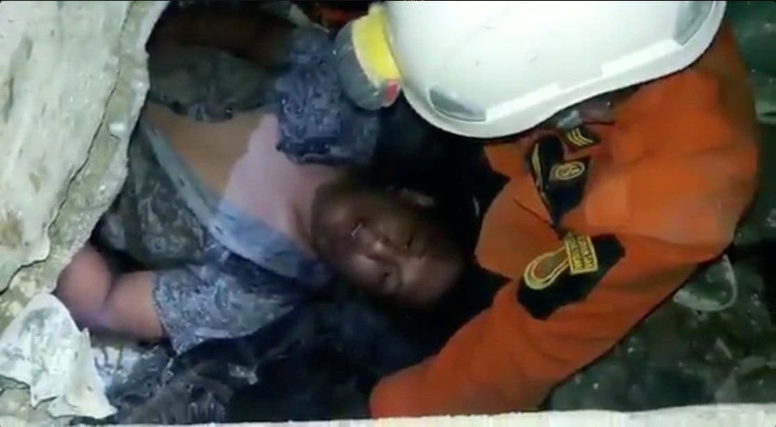 Social media picture of a rescuer tending to a man trapped in the Mandala Finance building after an earthquake in Palu. (Reuters)