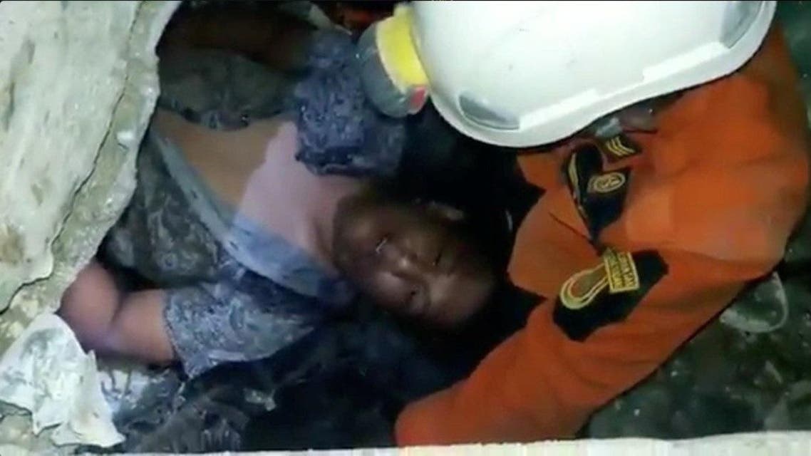 Social media picture of a rescuer tending to a man trapped in the Mandala Finance building after an earthquake in Palu. (Reuters)