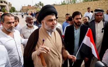 Moqtada al-Sadr shows his ink-stained index finger outside a polling station in Najaf on May 12, 2018 as the country votes in the first parliamentary election since declaring victory over ISIS. (AFP)