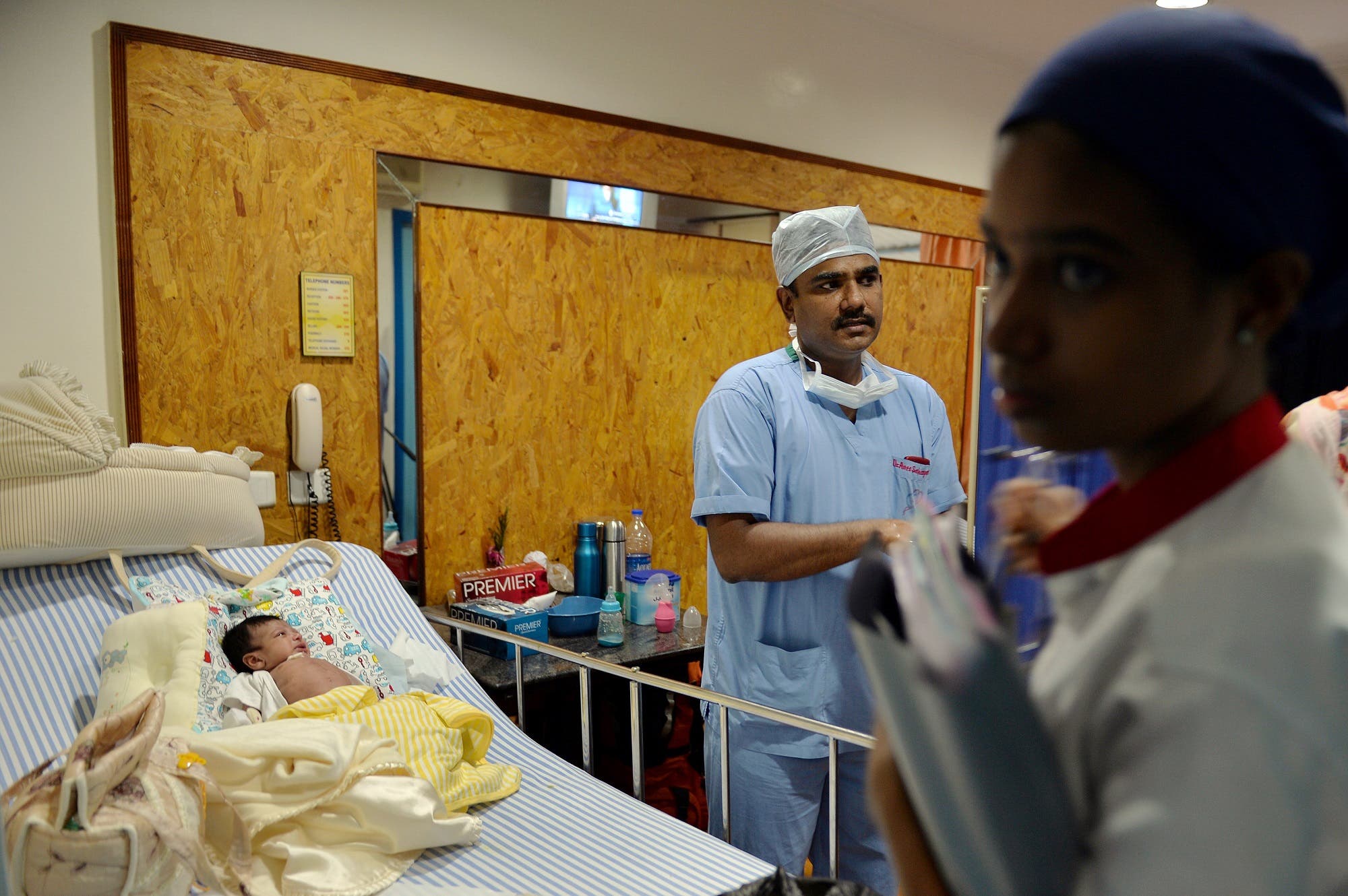A cardiac surgeon visiting one-month-old Abdulla (L) from Bahrain, who underwent cardiac surgery at the Frontier Lifeline Hospital in Chennai on March 26, 2014. (File photo: AFP)