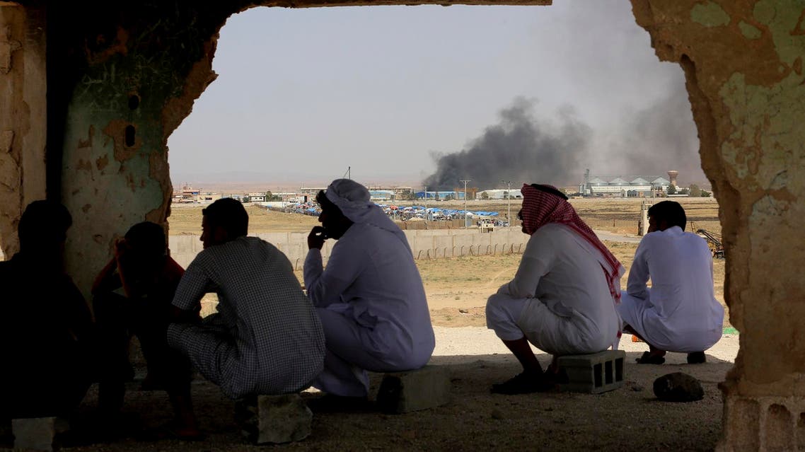 Jordanians watch aid deliveries to Syrians fleeing government offensive in the south as smoke from unknown fire rises on July 3, 2018. (File photo: AP)