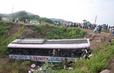 A crowd gathers around a bus that fell into a gorge in Jagtiyal district, in Telangana, on Sept. 12, 2018. (AP)