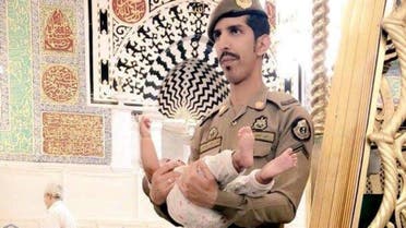 In a scene that took place at the Prophet’s Mosque in Madinah, the security man was captured on camera whilst holding the child. (Supplied)