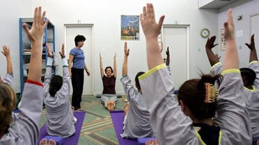 yoga instructor Azita, standing, leads prisoners during a session at the Dubai women's prison in Dubai, United Arab Emirates (AP)