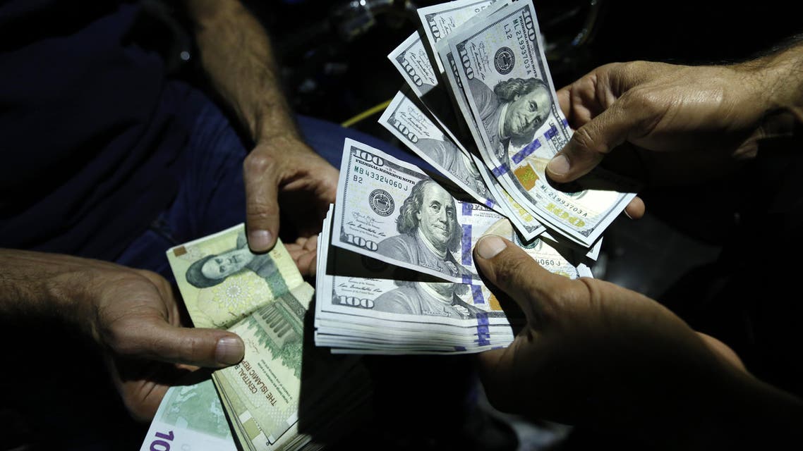 A man exchanges Iranian Rials against US Dollars at an exchange shop in the Iranian capital Tehran on August 8, 2018. US President Donald Trump warned the world the previous day against doing business with Iran as Washington reimposed "the most biting sanctions ever" on the Islamic republic, triggering a mix of anger, fear and defiance in Tehran.