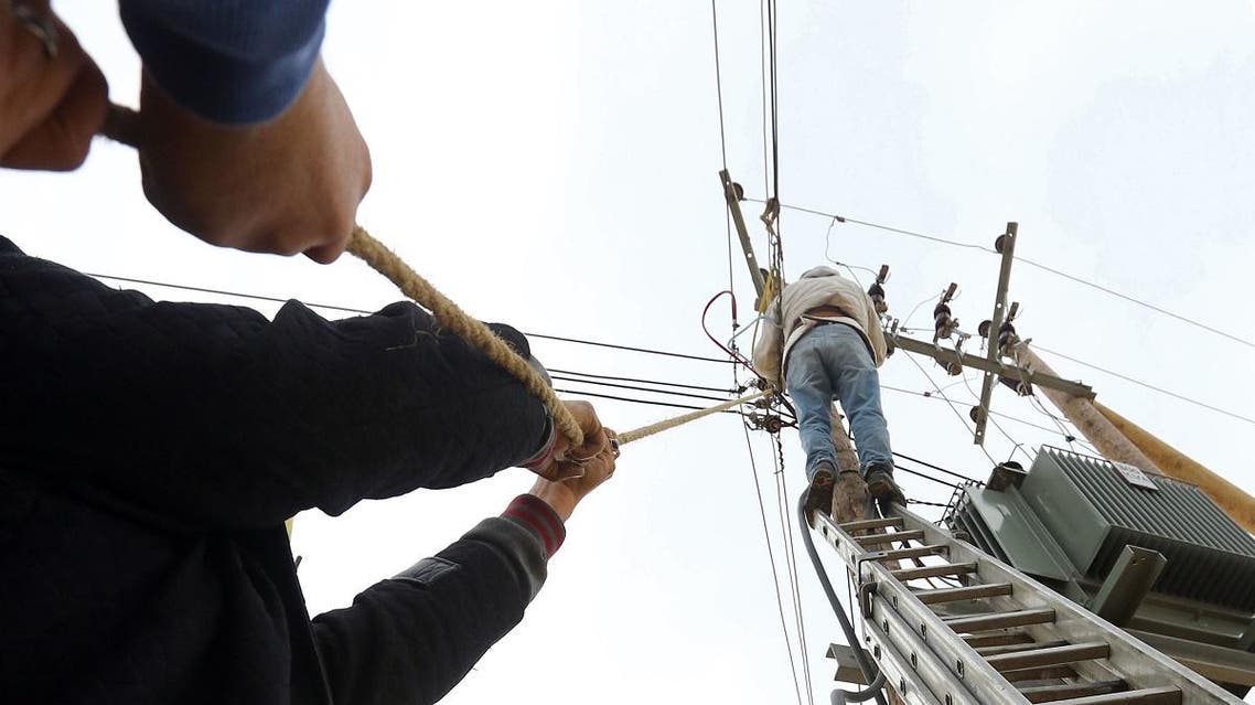 Employees of the General Electric Company fix cables in the Libyan capital, Tripoli, on January 19, 2017. (AFP)