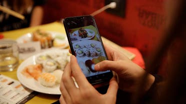 Customer Chiara Valenzano takes pictures of her dishes as she has lunch at the 'This is not a Sushi bar' restaurant, in Milan, Italy. (AP)