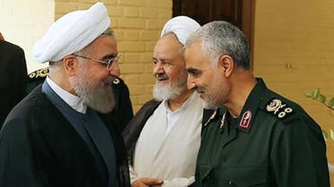 A handout picture provided by the office of Iranian President Hassan Rouhani shows him (L) shaking hands with Gen. Qassem Suleimani, in Tehran on September 15, 2015. (AFP)