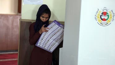 An Afghan woman searches for her candidate's name at a polling station during the Parliamentary elections in Kabul, Afghanistan, Saturday, Oct. 20, 2018. (AP)