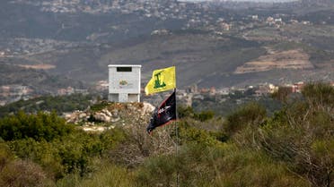 A picture taken from the Israeli side of the border shows the flag of Lebanon's Hezbollah Shiite movement and a religious flag reading "al-Hussein", in the southern Lebanese village of Aita al-Shaab on February 8 2018. 