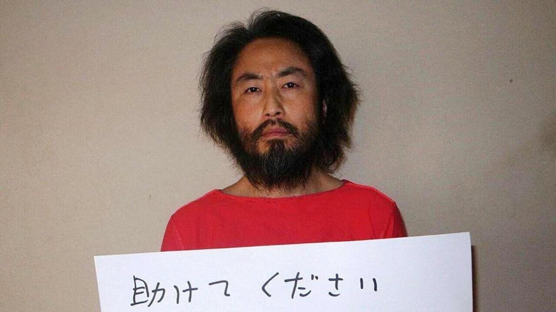 Photo shows Japanese freelance journalist Jumpei Yasuda holding a piece of paper with a handwritten message in Japanese. (AFP)