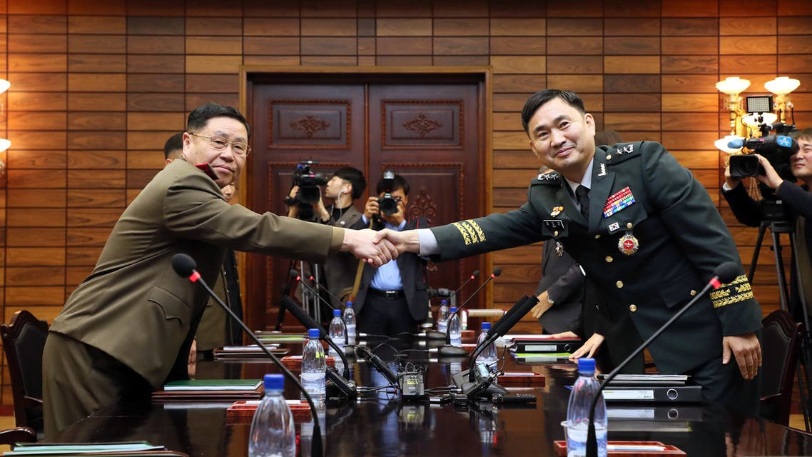 This handout photo taken on October 26, 2018 and provided by the South Korean Defence Ministry shows South Korea's chief delegate Major General Kim Do-gyun (R) shaking hands with his North Korean counterpart An Ik San (L) during their general-level military talks at the North side of the truce village of Panmunjom in the Demilitarized Zone (DMZ) dividing the two Koreas. The two Koreas agreed to remove 11 guard posts along the heavily-fortified border next month with a goal to possibly remove all guard posts in the future, senior military officials said on October 26.