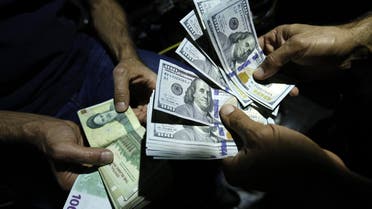 A file photo of a man exchanges Iranian Rials against US Dollars at an exchange shop in Tehran on August 8, 2018. (AFP)