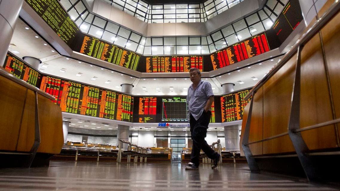 An investor walks in front of private stock trading boards at a private stock market gallery in Kuala Lumpur, Malaysia, Monday, Oct. 29, 2018. (AP)