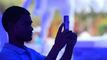 an Indian man takes a photo from his smartphone at a Durga Puja pandal in Allahabad. (AFP)