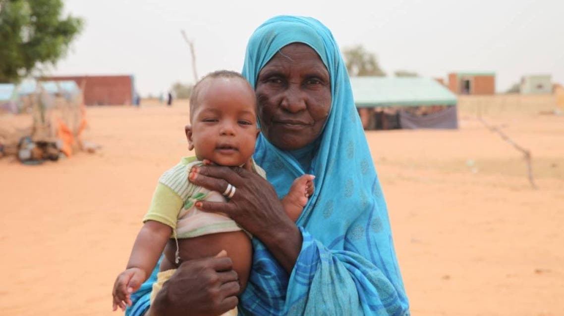 Salma Mint Mahmoud poses with a grandchild in the commune of Dar El Barka, Mauritania, October 20, 2018. (Thomson Reuters Foundation/Nellie Peyton)