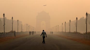 A man walks in front of the India Gate shrouded in smog in New Delhi. (Reuters)