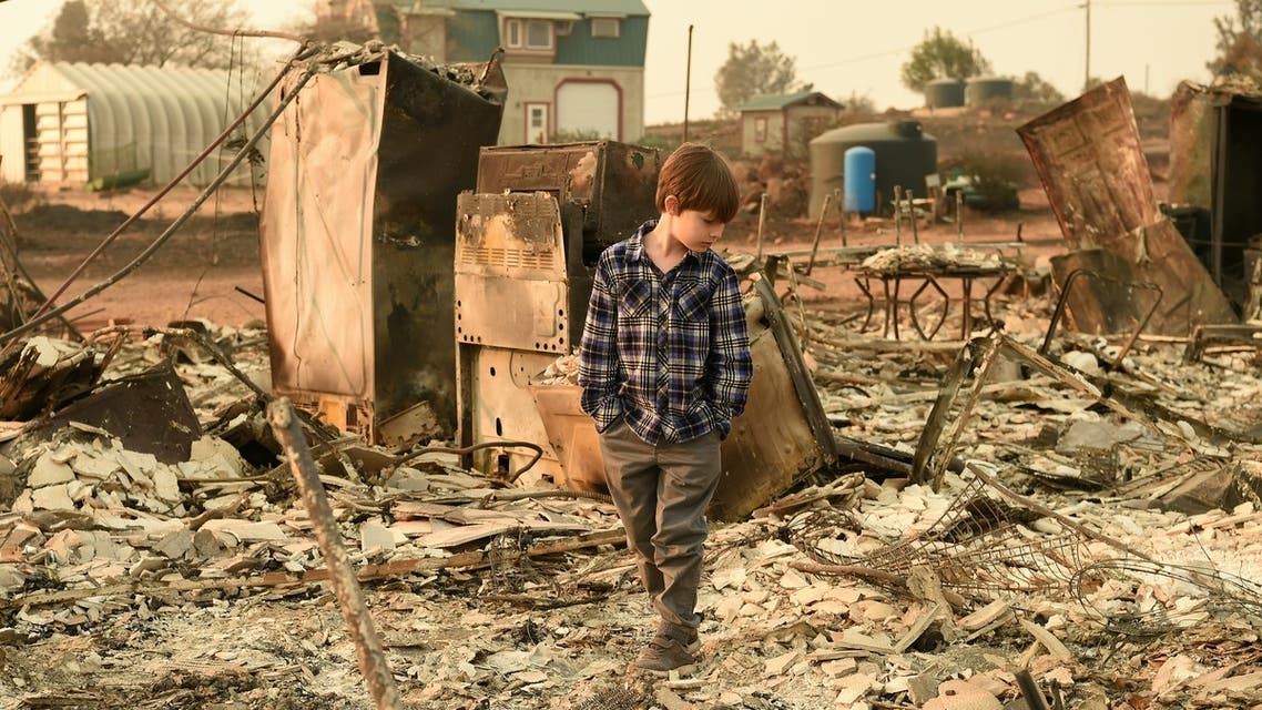 Jacob Saylors, 11, walks through the burned remains of his home in Paradise, California on November 18, 2018. The family lost a home in the same spot to a fire 10 years prior.