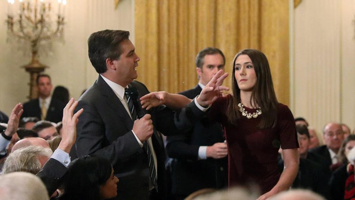White House intern reaches for microphone held by CNN's Acosta as he questions U.S. President Trump during news conference in Washington. (Reuters)