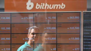 A man is reflected on a screen showing exchange rates of cryptocurrencies at Bithumb virtual currency exchange in Seoul. (AFP)
