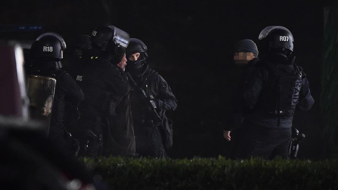 Members of the RAID elite police unit detain a man (2nd L) who was wearing a yellow vest and wielding a grenade, which could be tear gas, after he surrendered to police at the car wash station of the Espace Anjou shopping centre in Angers, western France, on November 23, 2018. (AFP)