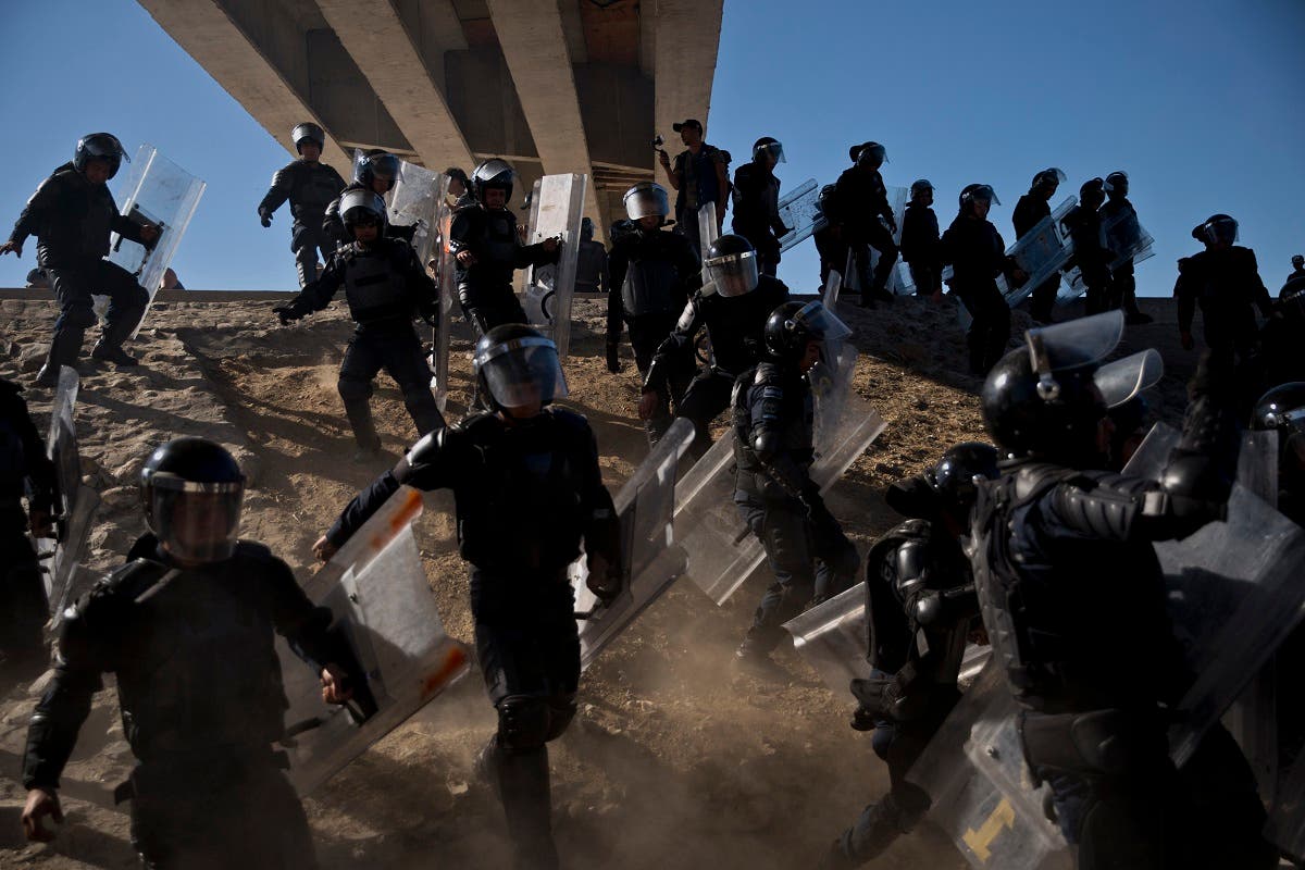 Mexican police run as they try to keep migrants from getting past the Chaparral border crossing in Tijuana, Mexico, Sunday, Nov. 25, 2018. (AP)