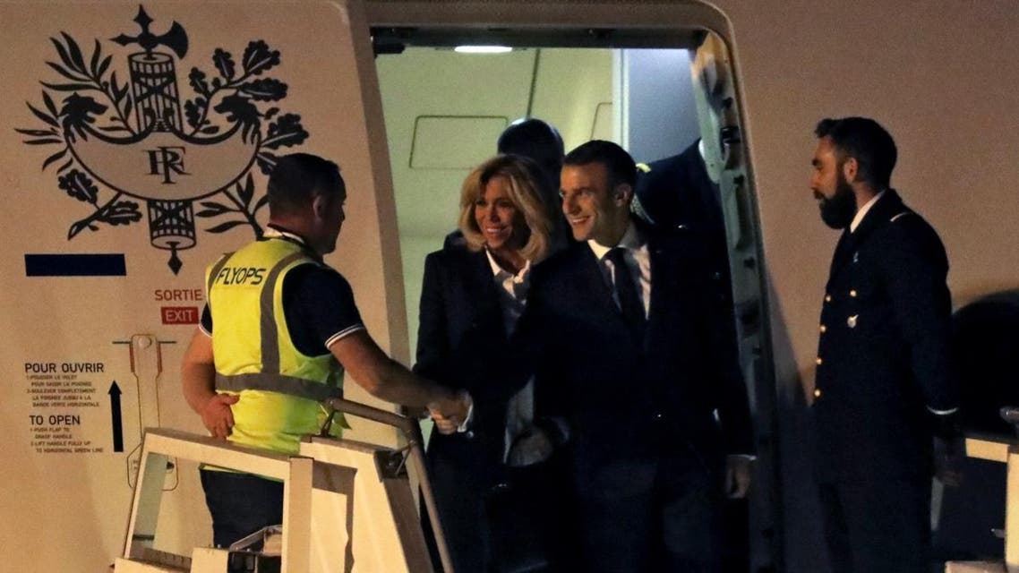 French President Emmanuel Macron (2nd R) next to First Lady Brigitte Macron, shakes hands with a crew member before leaving the plane, upon arrival at Ezeiza airport, in Buenos Aires province, on November 28, 2018. (AFP)