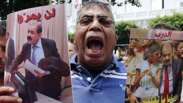 A protester shouts slogans as he holds portraits of the late Tunisian opposition leader Chokri Belaid, who was assassinated in 2013. (File photo: Reuters