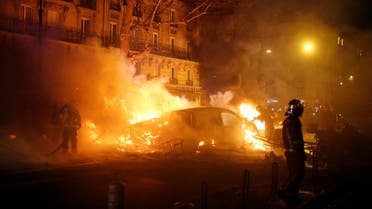 Firemen extinguish burning cars set afire by protesters wearing yellow vests near the Place de l'Etoile in Paris. (Reuters)