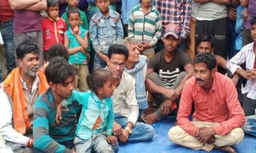 Three-year-old boy (in green shirt) sitting in the lap of his father who lost him in the gamble. The victor is seen in red shirt. (Supplied)