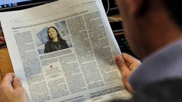 An illustration shows a journalist reading a news page about tech giant Huawei in The Globe and Mail in Montreal, Canada, on December 6, 2018. (AFP)