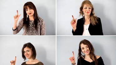 Syrian women pose for photos as they show their ink-stained fingers after casting votes in Damascus on April 13, 2016. (AP)