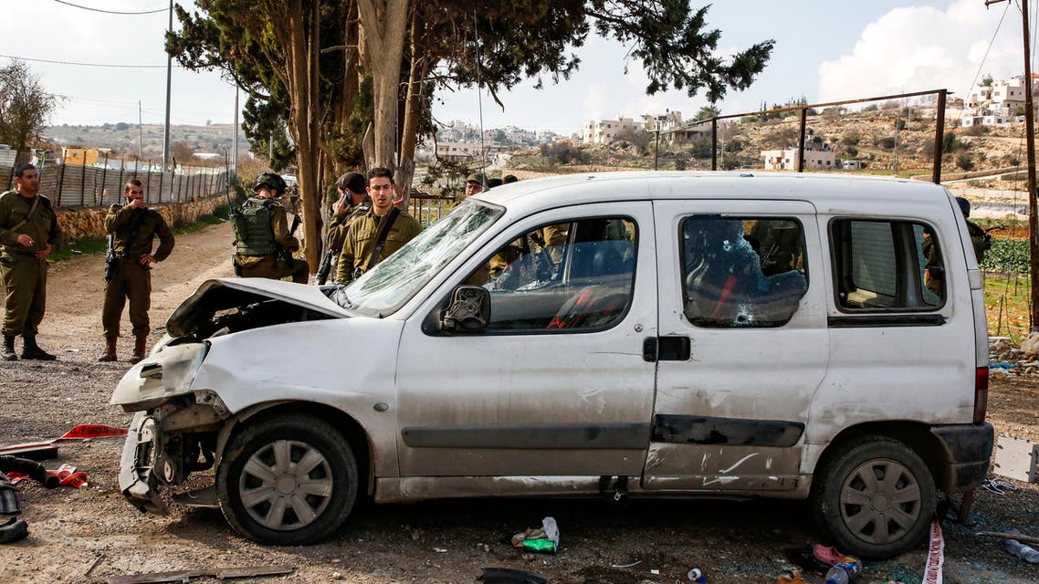 Israeli soldiers standing by a damaged car at the scene of an attack where a Palestinian man rammed a vehicle into three Israeli soldiers on November 26, 2018. (AFP)