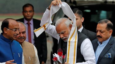 India's PM Modi Modi removes a stole given to him by a minister upon his arrival at the Parliament on the first day of the winter session in New Delhi. (Reuters)