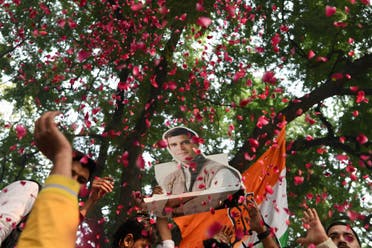 A bust placard of Congress President Rahul Gandhi is seen through a shower of rose petals as party supporters celebrate in New Delhi on December 11, 2018. (AFP)